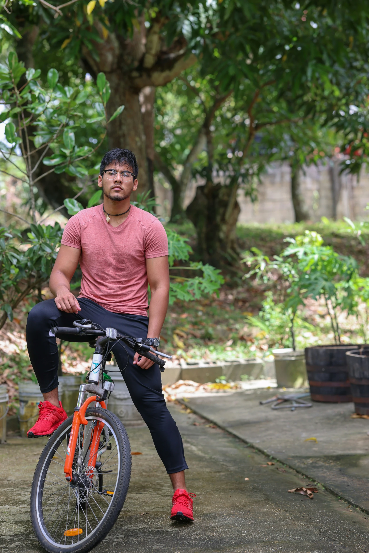 man sitting on bicycle with trees in the background