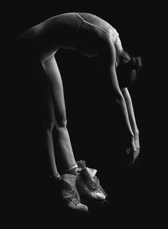 a woman performs a hand stand while wearing sneakers