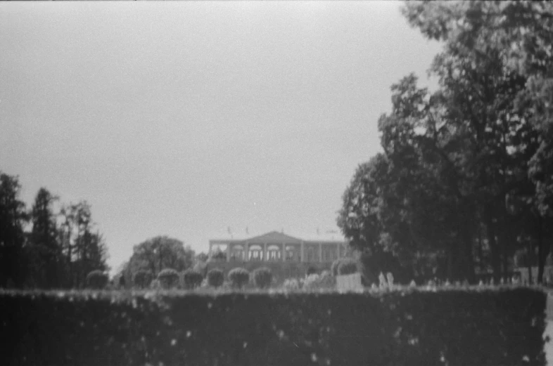 a tall building is over water near some trees