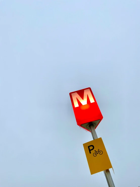 the parking sign has a red m on it