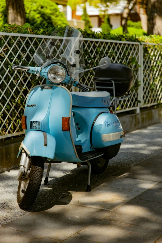 a blue scooter is parked on a sidewalk