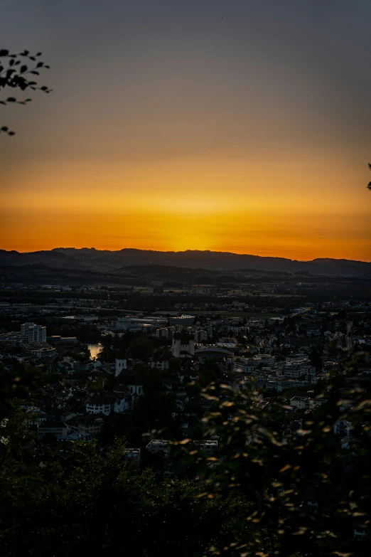 an overcast evening in a city with the sun setting