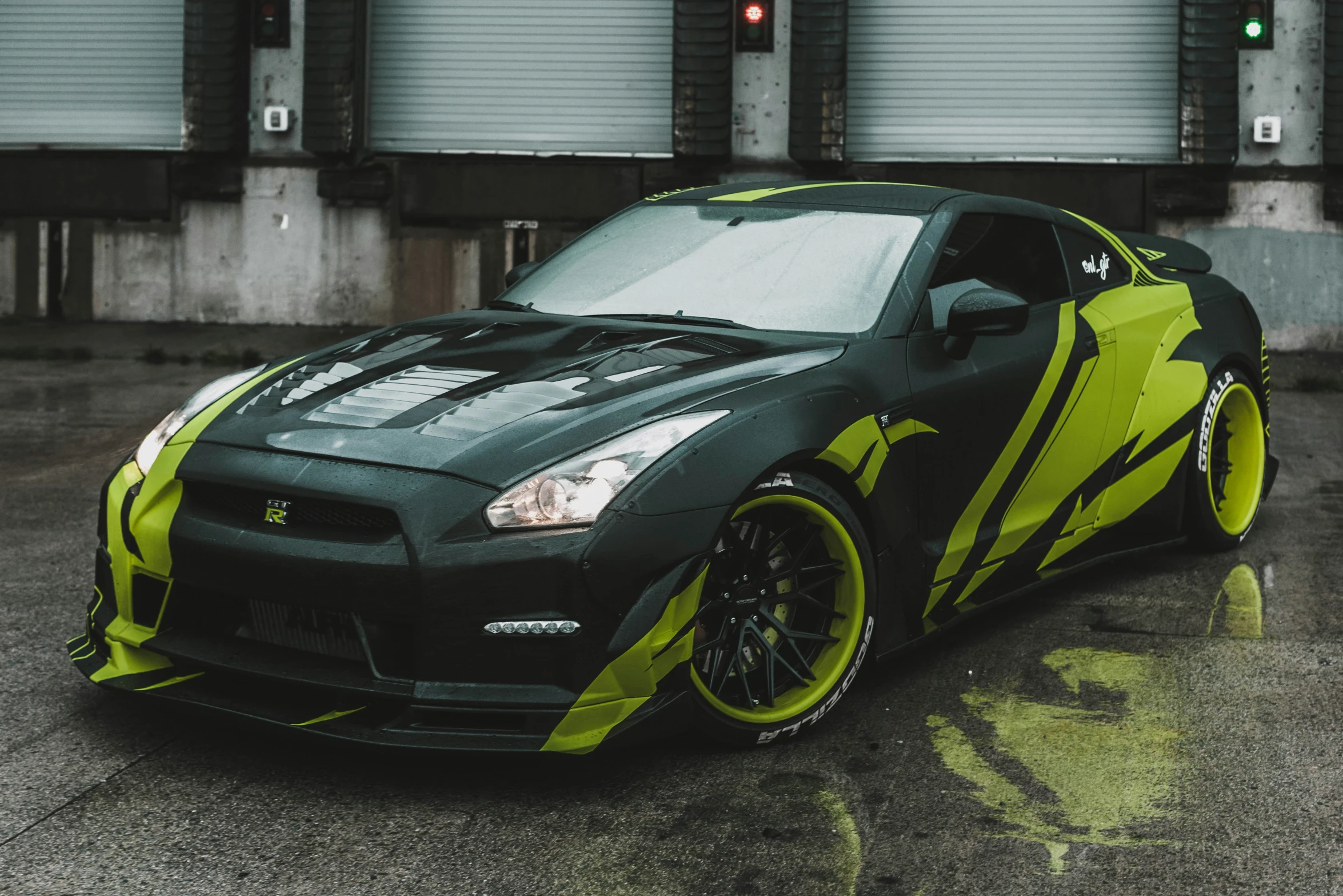 a green sports car parked in front of two buildings