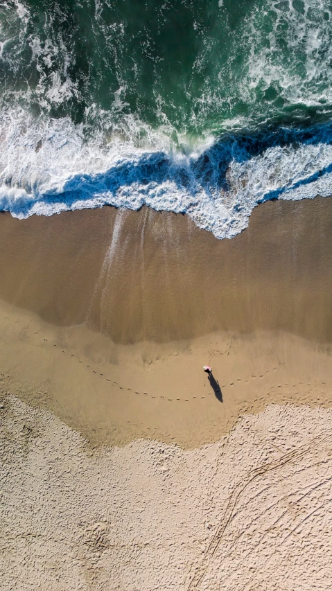 a surfers board on the beach under an overhead view of the water