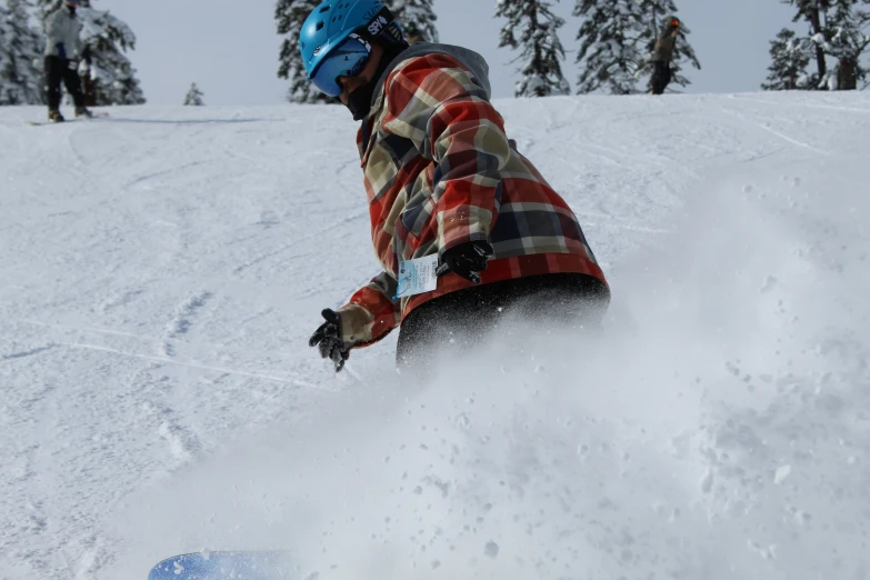 snowboarder in plaid shirt going down a mountain slope