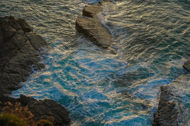 two rocks in the ocean with water below