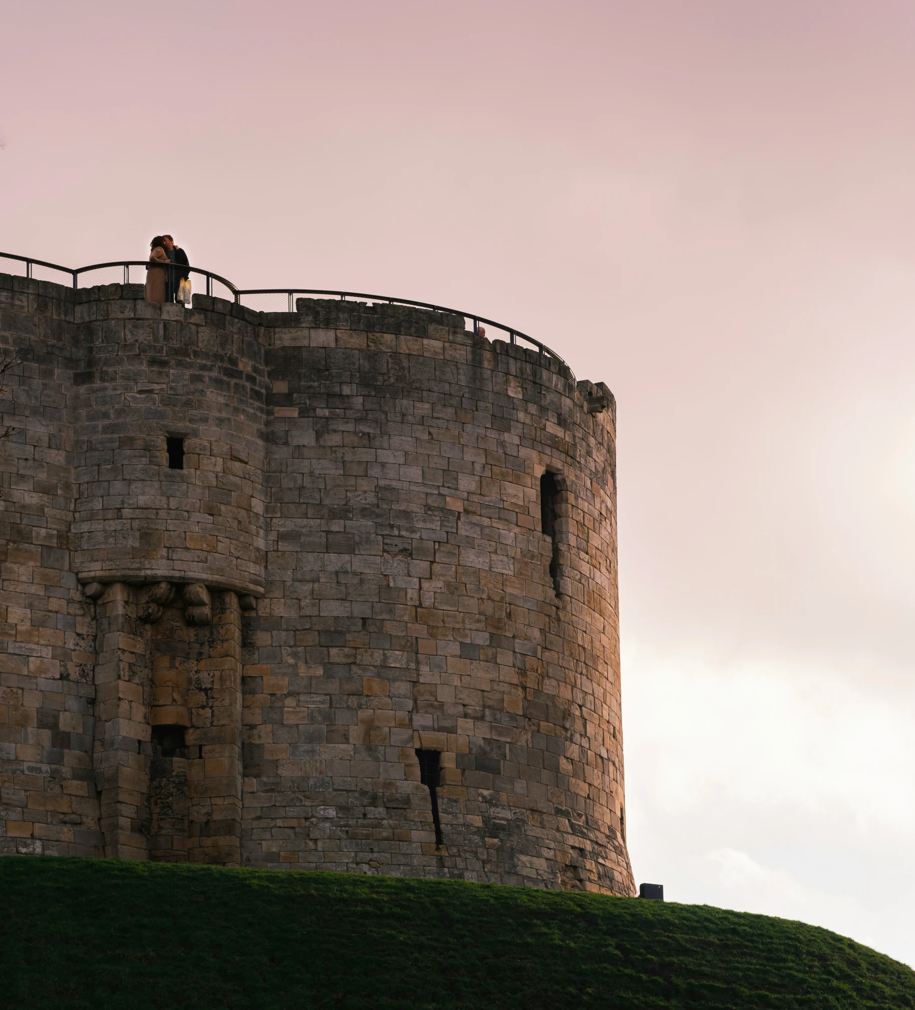 two people in red shirt on brick tower top