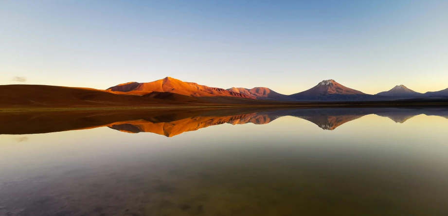 mountains are reflecting in the water on a sunny day