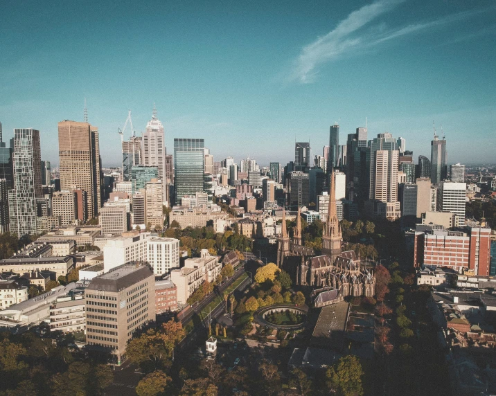 a large group of buildings are in the distance with trees