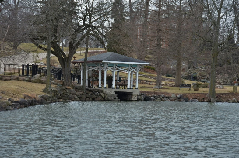 a gazebo with trees and other houses in the background