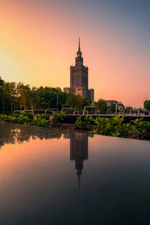 a tall building with a spire stands above a body of water