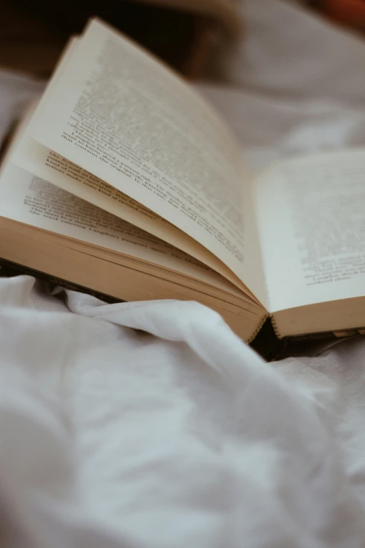 an open book on a bed with a white comforter
