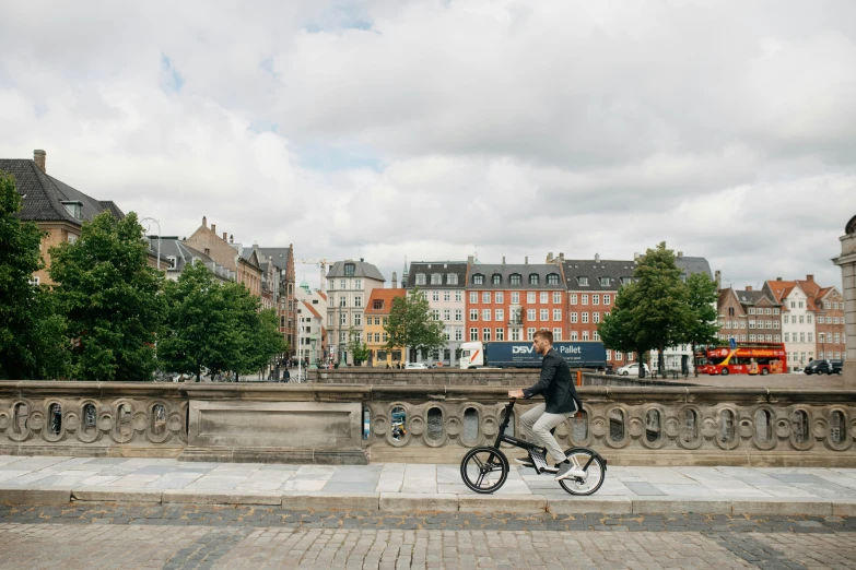 man riding bicycle in city overpass on cloudy day