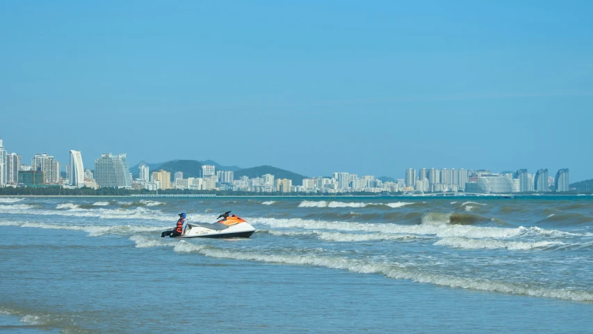 two people riding a speedboat across the beach