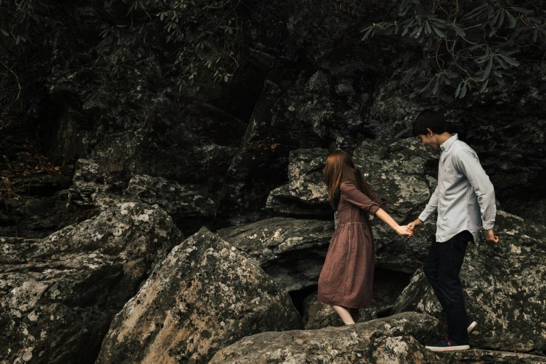 young couple walking in rocky terrain holding hands