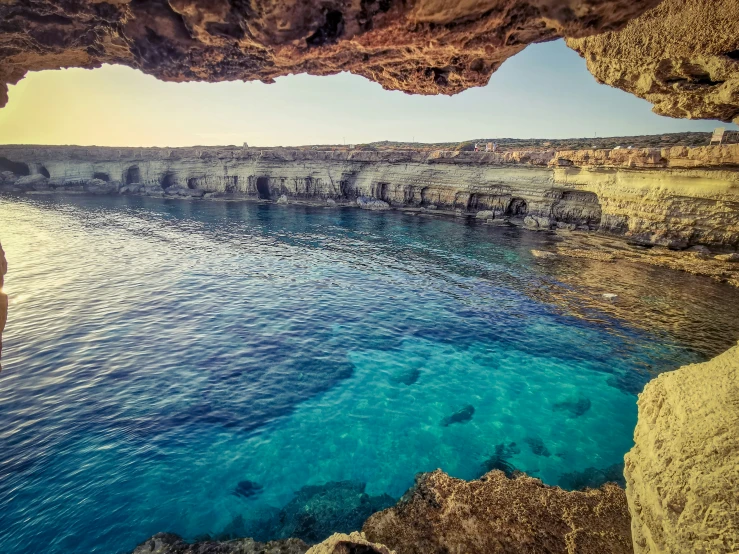 a man stands on the rocks looking out to sea