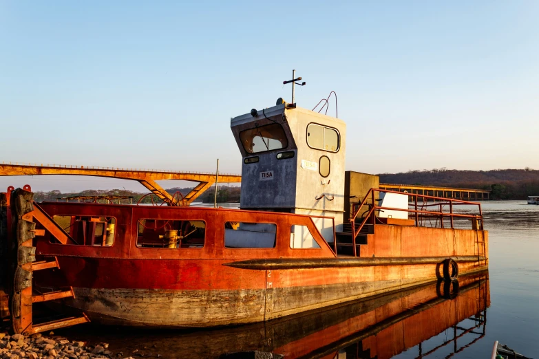 a very old rusted and rusty boat on water