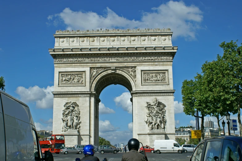 two motorcycles and scooters parked next to a stone archway