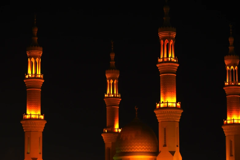 two tall minages lit up at night with light on