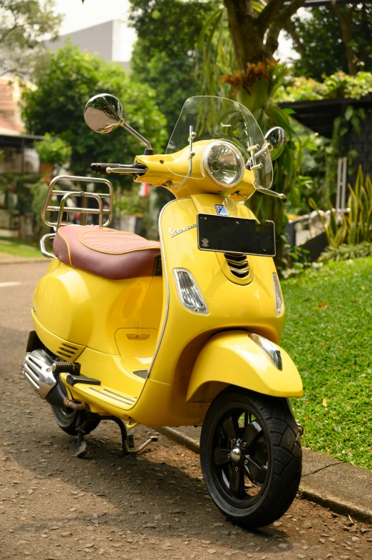 a yellow motor scooter parked on the side of a road