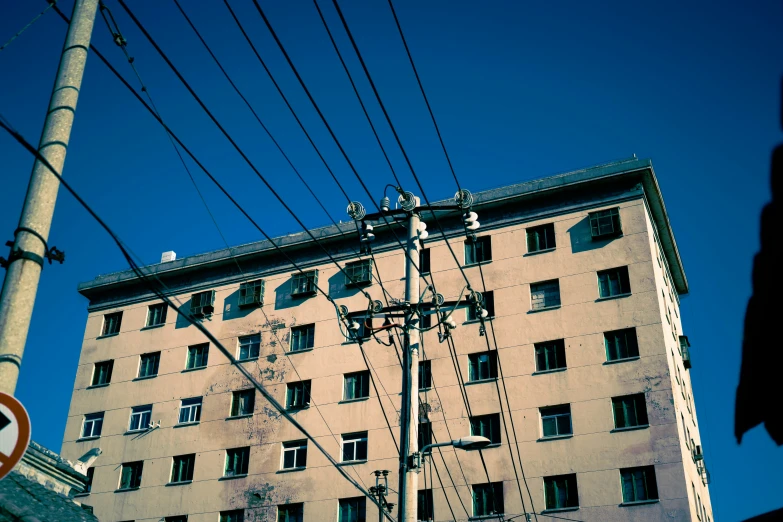 a tall building on a street corner with wires above it