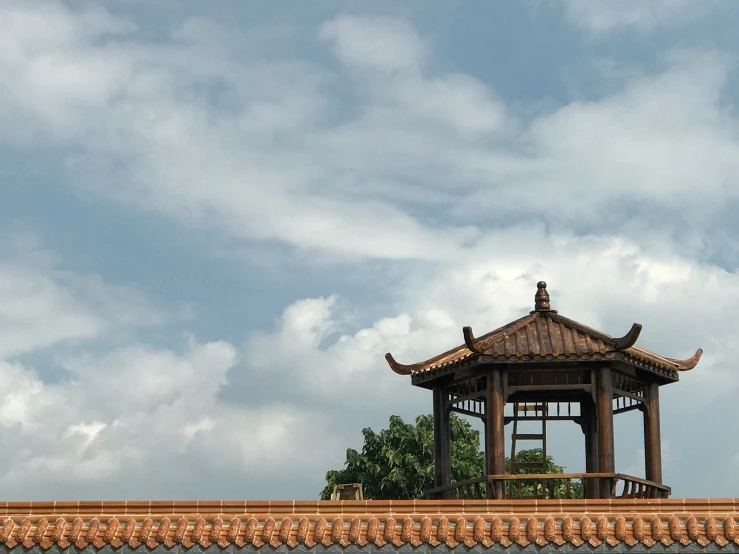 a clock tower sitting above a wall near trees