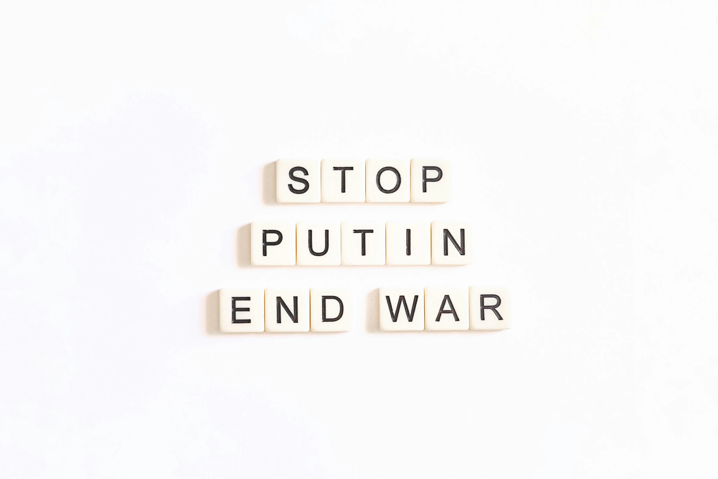 the words stop and puttin'end war written in scrabble type