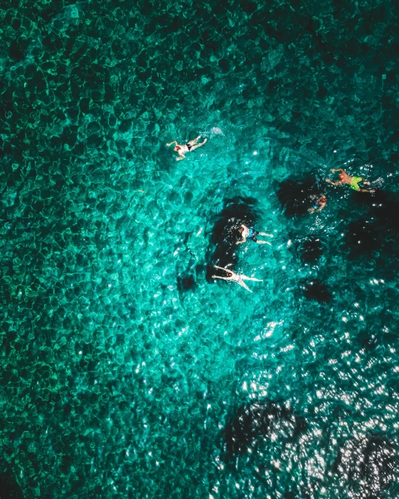 there are two surfers in the ocean near some rocks