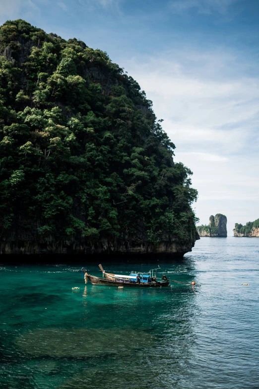 a boat floating on top of the ocean near trees