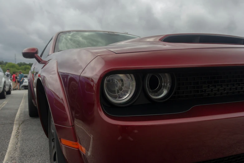 the front lights of a red car and a street scene