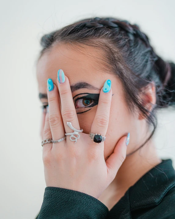 a woman is posing with her hands on her face