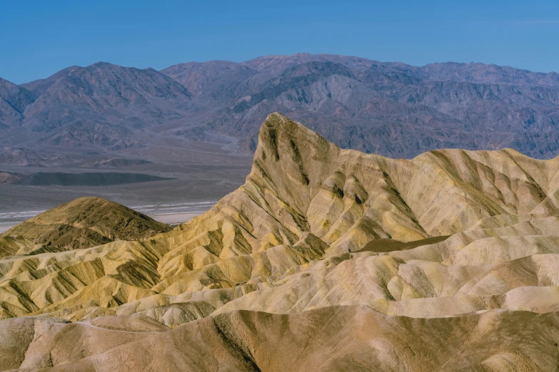 a rocky mountain that has mountains in the background