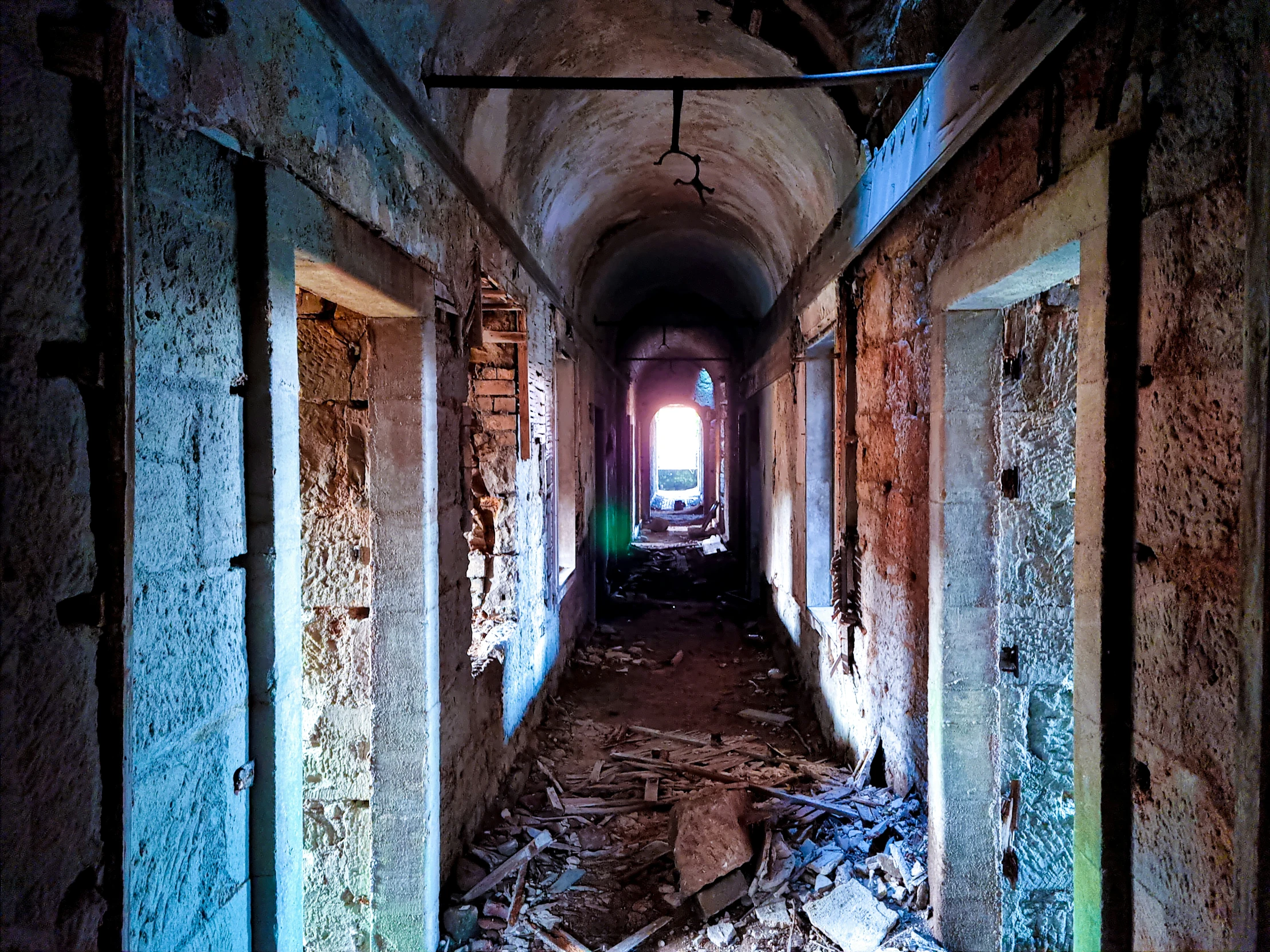 a long hallway with light shining through the tunnel