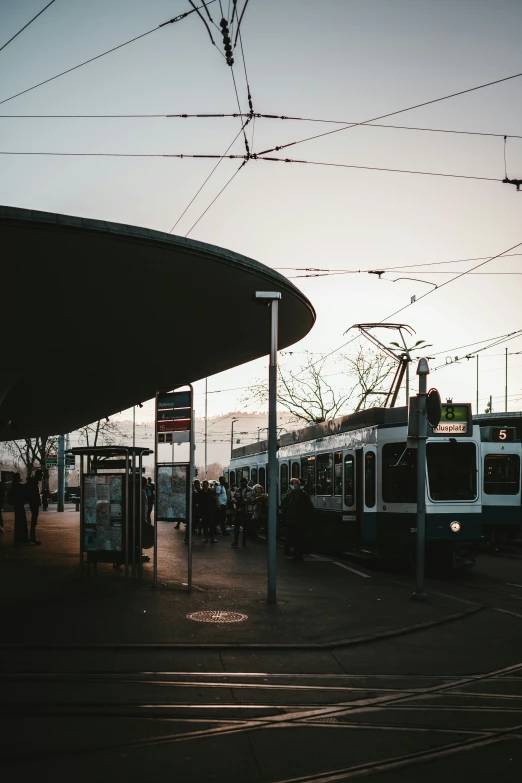 commuter trains wait on the tracks at sunset