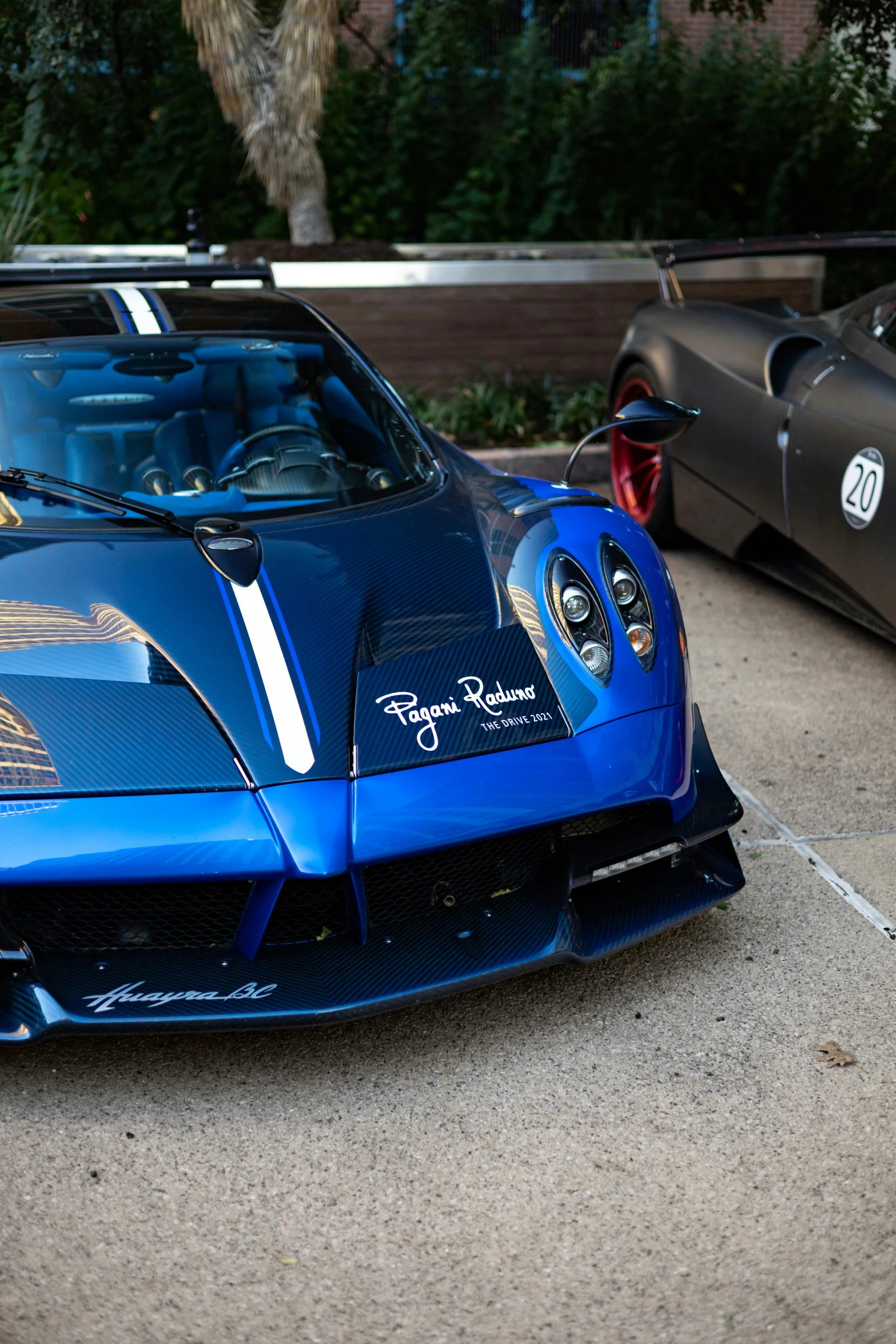 a blue sports car is parked beside other cars