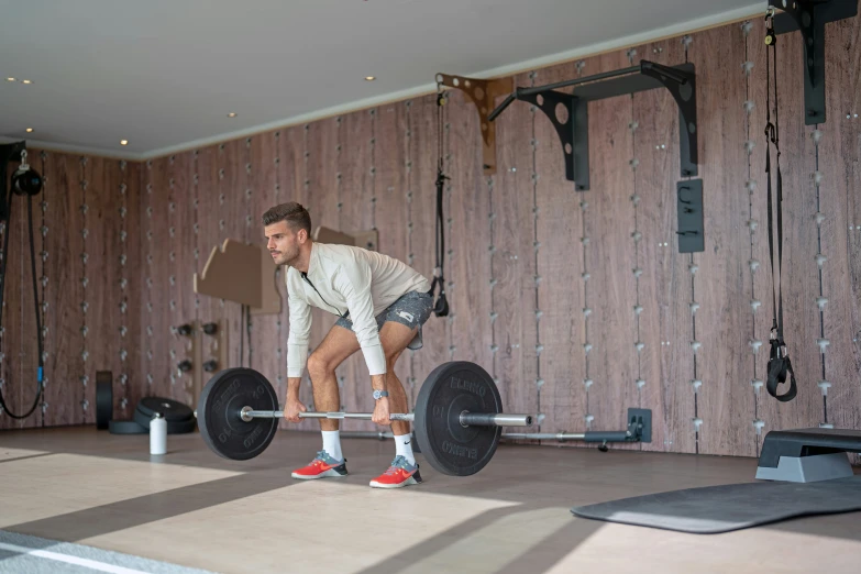 a man lifting a barbell in a room