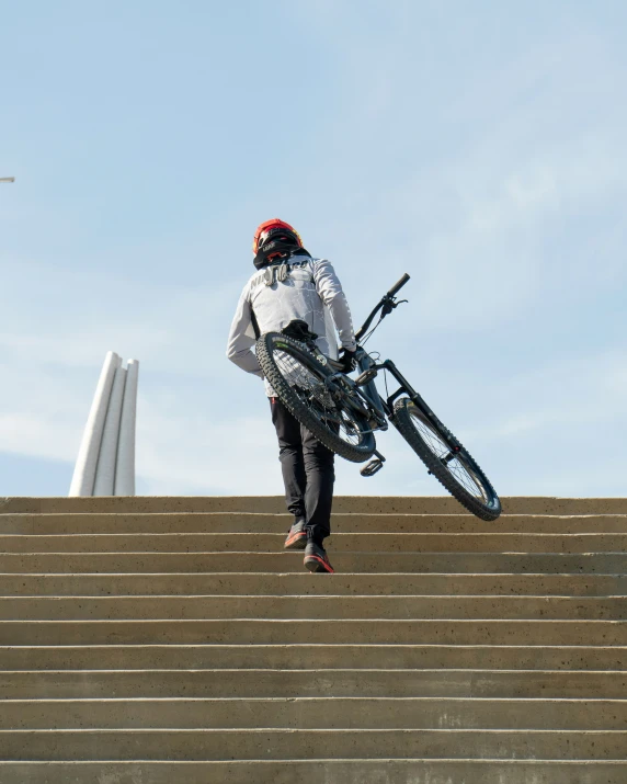 a man with a helmet and bicycle on top of a stair case