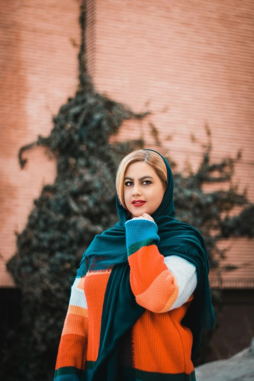 a young woman in a shawl is standing outside