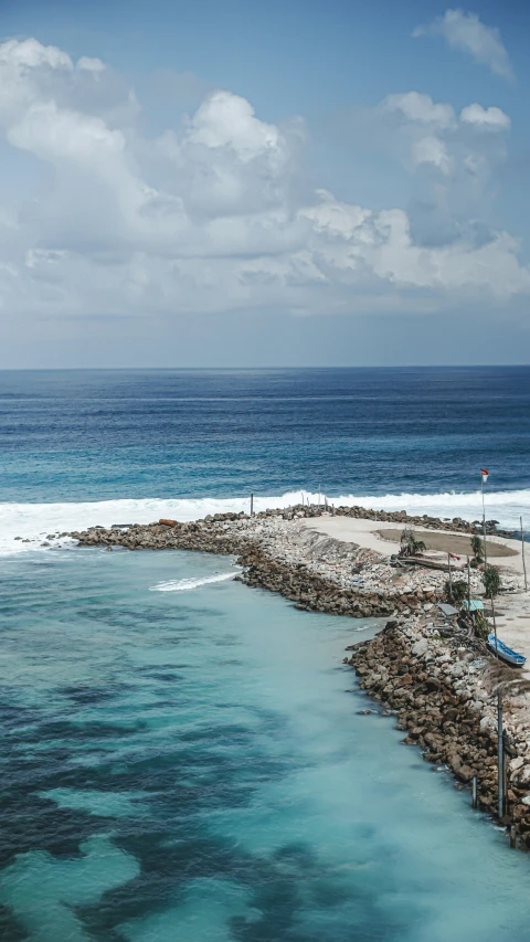 the ocean next to a sandy shore near the beach