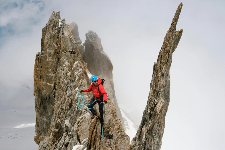 a climber ascending a mountain side on a cloudy day