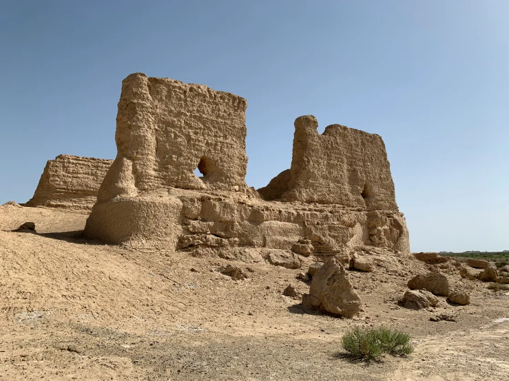 a rock formation near desert terrain under a blue sky