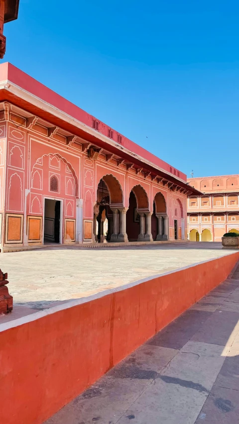 a building that is red and pink with pillars