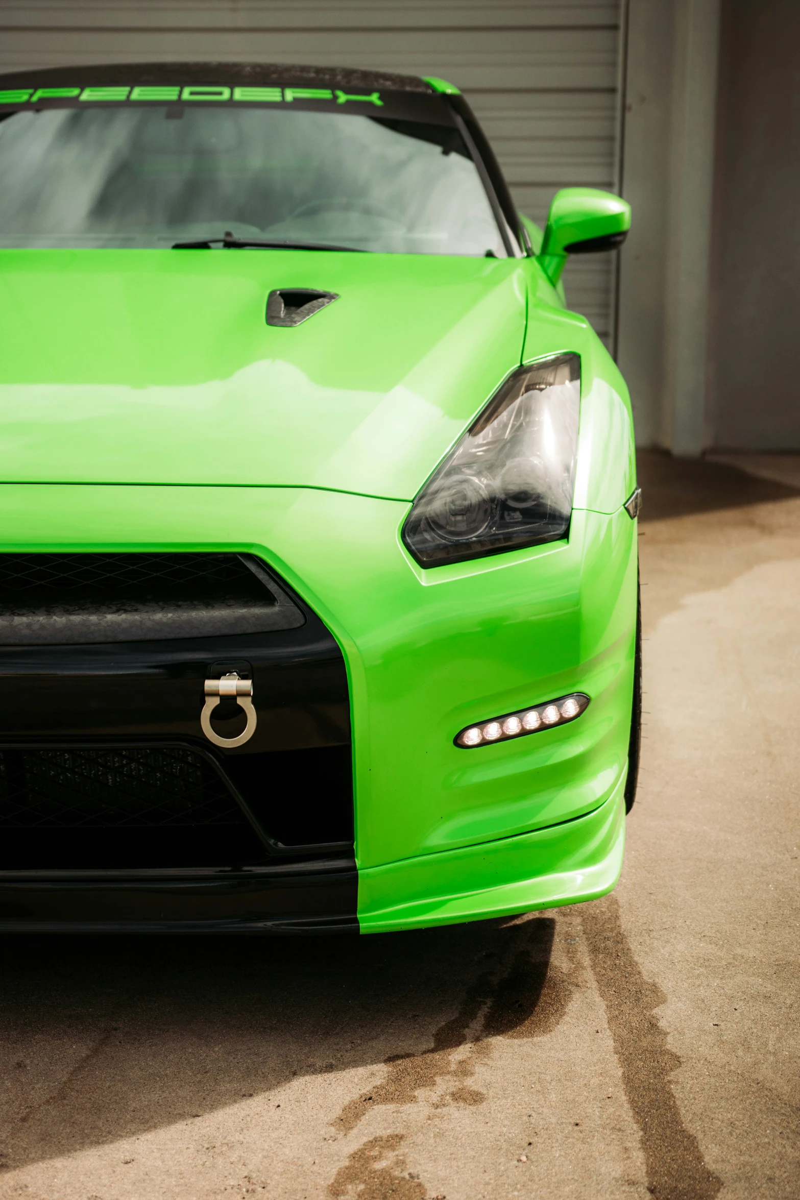 closeup of the front and headlamps of a lime green sports car