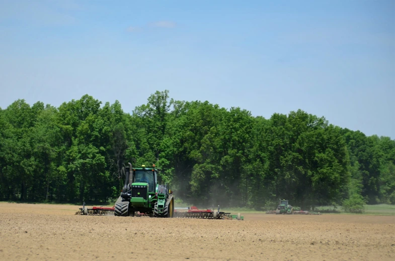 tractor in field spraying crops and trees