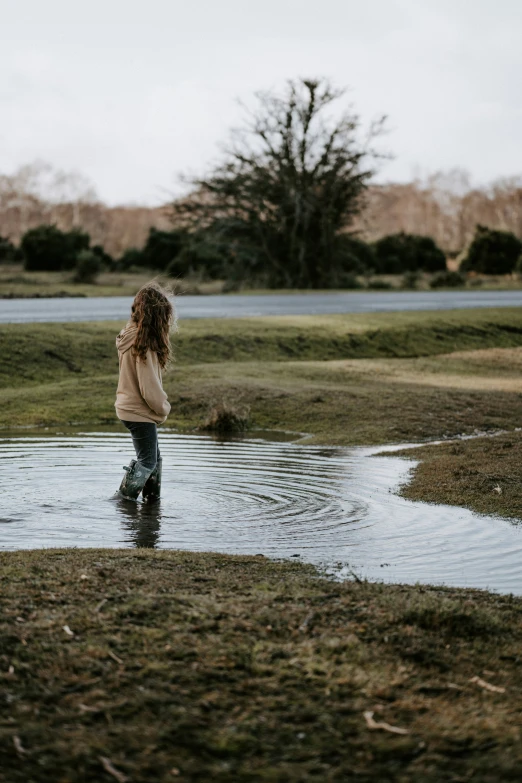 a little boy that is standing in some water