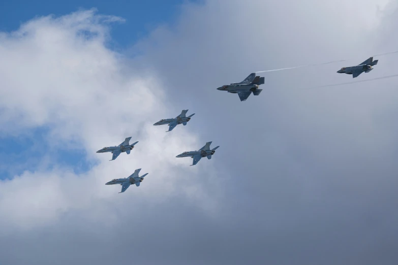 five fighter jets fly in formation against the blue sky