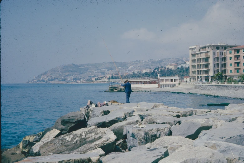 a person standing on a rocky beach by the ocean