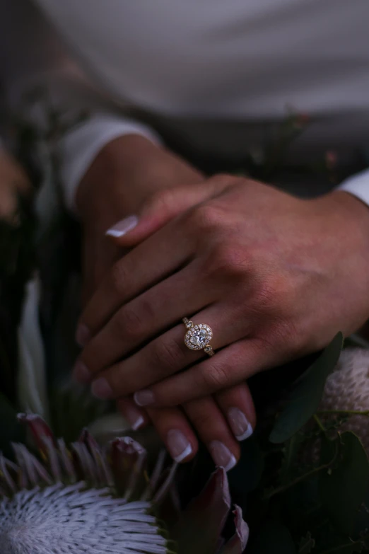 a bride holds her wedding ring on the finger