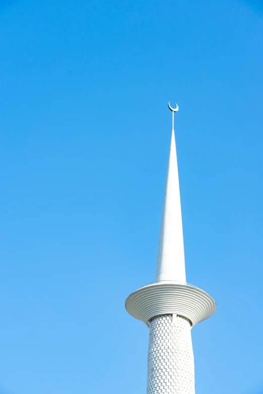 a white tower with a small weather vein