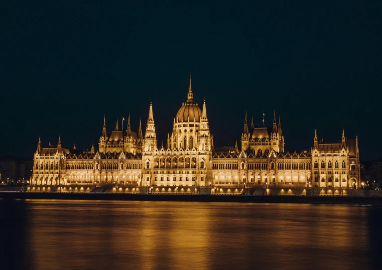 a lit up building is at night by the water